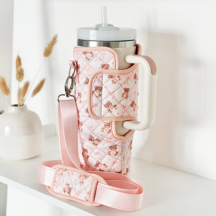 Pink quilted Coconut Lane Tumbler Carry Case with matching strap displayed on a white shelf.