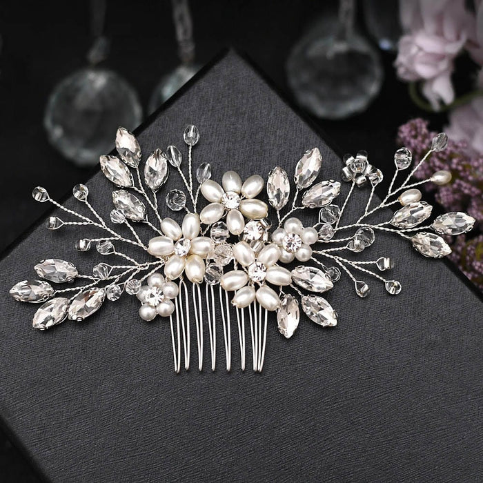 A decorative hair comb adorned with pearl-like beads and sparkling crystal stones creates a floral, leafy design for elegant occasions.