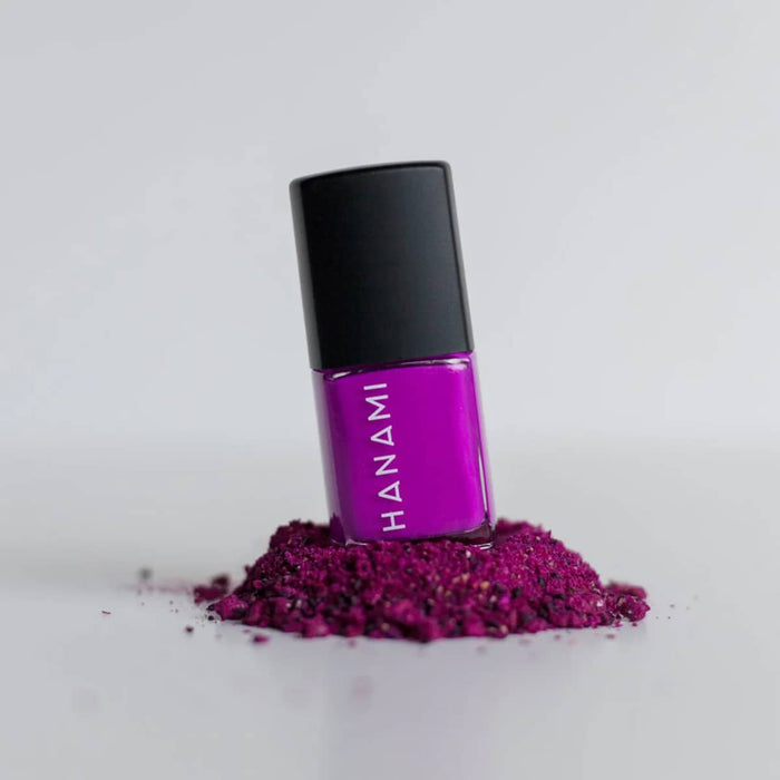 Purple nail polish bottle with black cap on a white background.